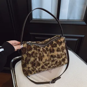 Sac à bandoulière en fausse fourrure léopard avec sangle en cuir brun et détails argentés