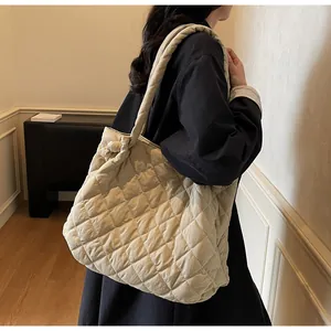 Détail d'un sac cabas beige matelassé avec motif losange et nœud doux sur le côté