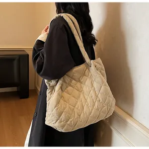 Vue détaillée du sac fourre-tout matelassé beige avec bandoulière large et tissu souple