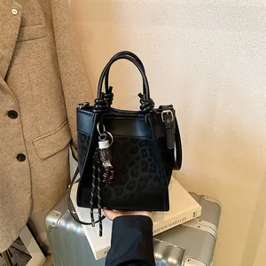 Sac seau noir avec imprimé léopard, poignée nouée et breloque perlée pour un look chic