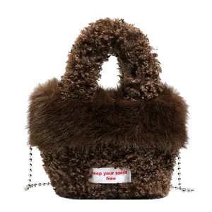 Borsa a mano in pile marrone con etichetta keep your spirit free e catena in argento