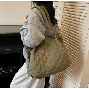Gros plan sur le sac fourre-tout matelassé vert olive montrant sa texture et ses coutures