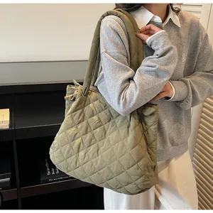 Détail du sac fourre-tout matelassé vert olive avec coutures en losange et nœud latéral