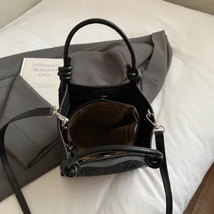Sac seau noir gaufré léopard avec poignées nouées et une bandoulière amovible chic