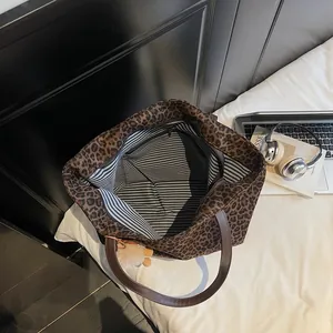 Leopard print large tote bag with brown handles and white pompom for casual office commute