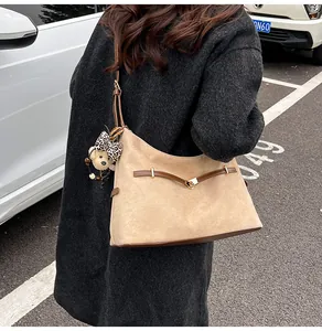 Detail of khaki suede tote bag with leopard print bear charm and slim shoulder strap
