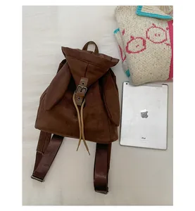 Detalle de la mochila vintage marrón con orejas de conejo y textura de gamuza suave