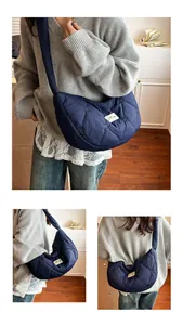 Detail view of heart-quilted pattern and fabric label on a navy blue cloud tote bag