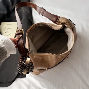 Large brown suede tote bag with leopard bow and adjustable strap on white bedding