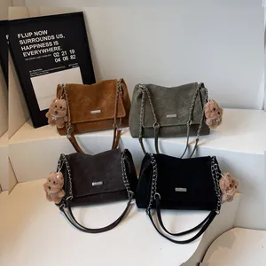 Bolsos de hombro en ante con correas de cadena en cuatro colores y colgante de oso