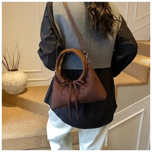 Dark brown suede handbag detail featuring plush fleece handles and a decorative bow tie