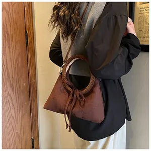 Retro brown suede crossbody bag with textured top handle and bow detail on model