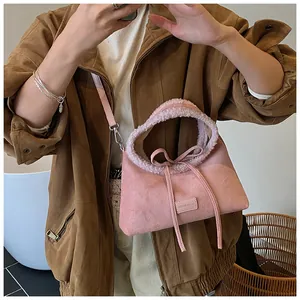 Detailed view of pink velvet handbag with faux shearling trim and bow tie decoration