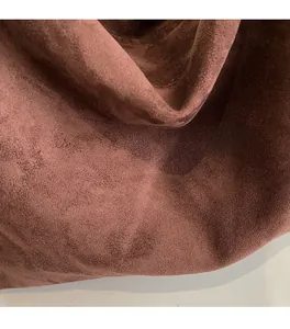 Detailed macro view of chocolate brown suede fabric with soft matte texture and draping