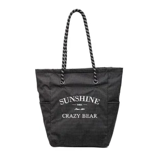 Minimalist black and white checkered canvas tote bag with woven handles and SUNSHINE print