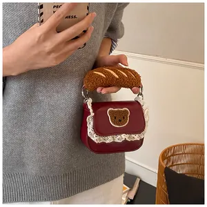 Detail of red lace handbag with plush bear patch and baguette-style handle