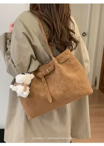 Dettaglio della borsa Boston marrone vintage con fibbie e un simpatico ciondolo a cucciolo