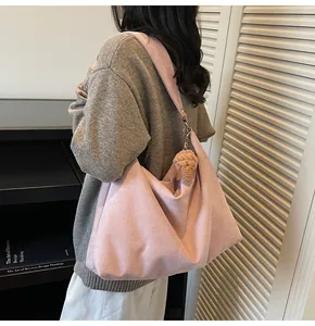 Detail of pink hobo tote bag in soft suede fabric with ice cream charm and wide strap