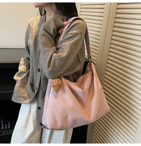 Detail of pink faux suede tote bag with ice cream charm on casual model outfit