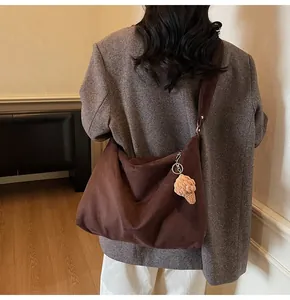 Detail of dark brown tote bag with beige crochet charm in a cozy home setting