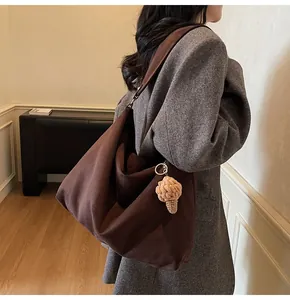 Detail view of oversized coffee brown tote bag with cute ice cream plush pendant