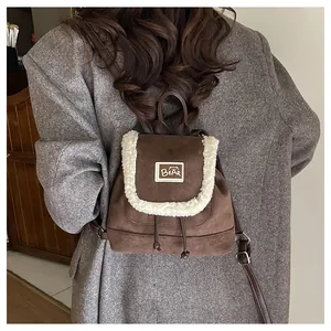 Detail of vintage brown suede backpack with cream shearling trim and drawstring closure