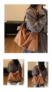 Detail view of large brown suede tote bag featuring a knitted charm and soft texture
