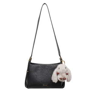 French vintage black leather underarm bag with a cute white bunny pendant charm