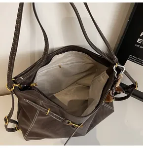 Detail of the tote bag interior showing grey lining, zipper pocket, and white contrast stitching