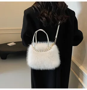 Rückansicht einer weißen Plüschtasche mit Perlenkette auf einem schwarzen Wollmantel