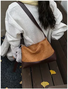 Detalle del bolso tote plisado caqui con correa marrón oscuro y colgante de conejo lindo