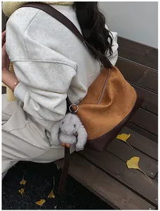 Detalle de bolso tote vintage mate con textura plisada y llavero de conejo de peluche