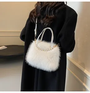 Detailaufnahme einer weißen Plüsch-Handtasche mit elegantem Perlenketten-Griff-Design