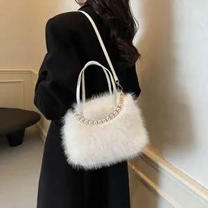Weiße Webpelz-Handtasche mit Perlengriff und Schultergurt auf schwarzem Blazer