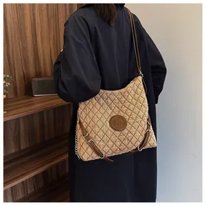 Close-up of quilted mustard yellow tote with vintage leather logo and buckle details