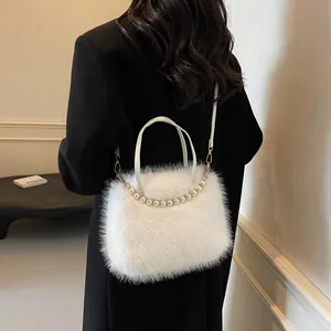 Detail der Plüschtasche aus Kunstfell mit elegantem Perlengriff und Goldhaken