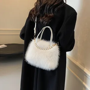 Weiße Plüschtasche mit Perlenkette getragen über einem schwarzen Mantel für Damen