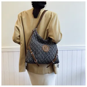 Detail of grey quilted denim hobo bag with M leather patch shown on model back view