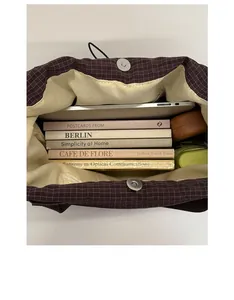 Spacious interior of dark brown plaid tote bag showing laptop and daily essentials