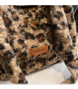 Close-up of leopard print faux fur texture and brown leather label on the large shoulder bag