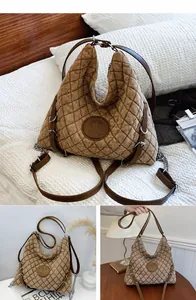 Detail of coffee brown quilted tote bag with letter M patch and leather shoulder strap