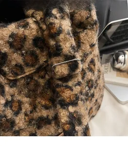 Detail view of the leopard print plush bag showing the adjustable metal strap buckle