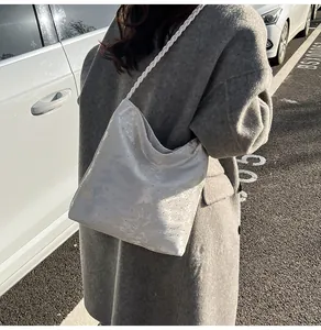 Detail of silver metallic hobo bag with thick white braided rope shoulder strap