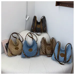 Minimalist quilted tote bags in four colors with chain straps on a white cushion
