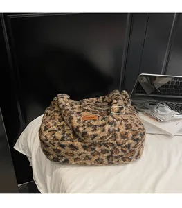 Detailed view of leopard print plush tote bag with faux fur texture and orange logo tag