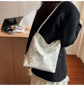Detail of cream shoulder bag with silver butterfly print and woven rope style strap