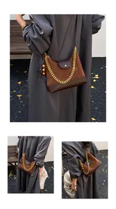 Detail of suede crossbody bag with gold chain and vintage wooden bead accessory