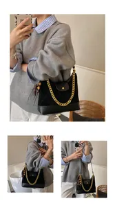 Close-up of black quilted suede shoulder bag featuring a gold chain and wooden bead charm