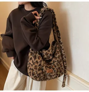 Detail of soft leopard print plush tote bag with brown leather brand tag and fuzzy texture