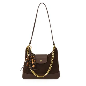 Deep brown suede shoulder bag with golden chain and retro wooden bead charms on white background